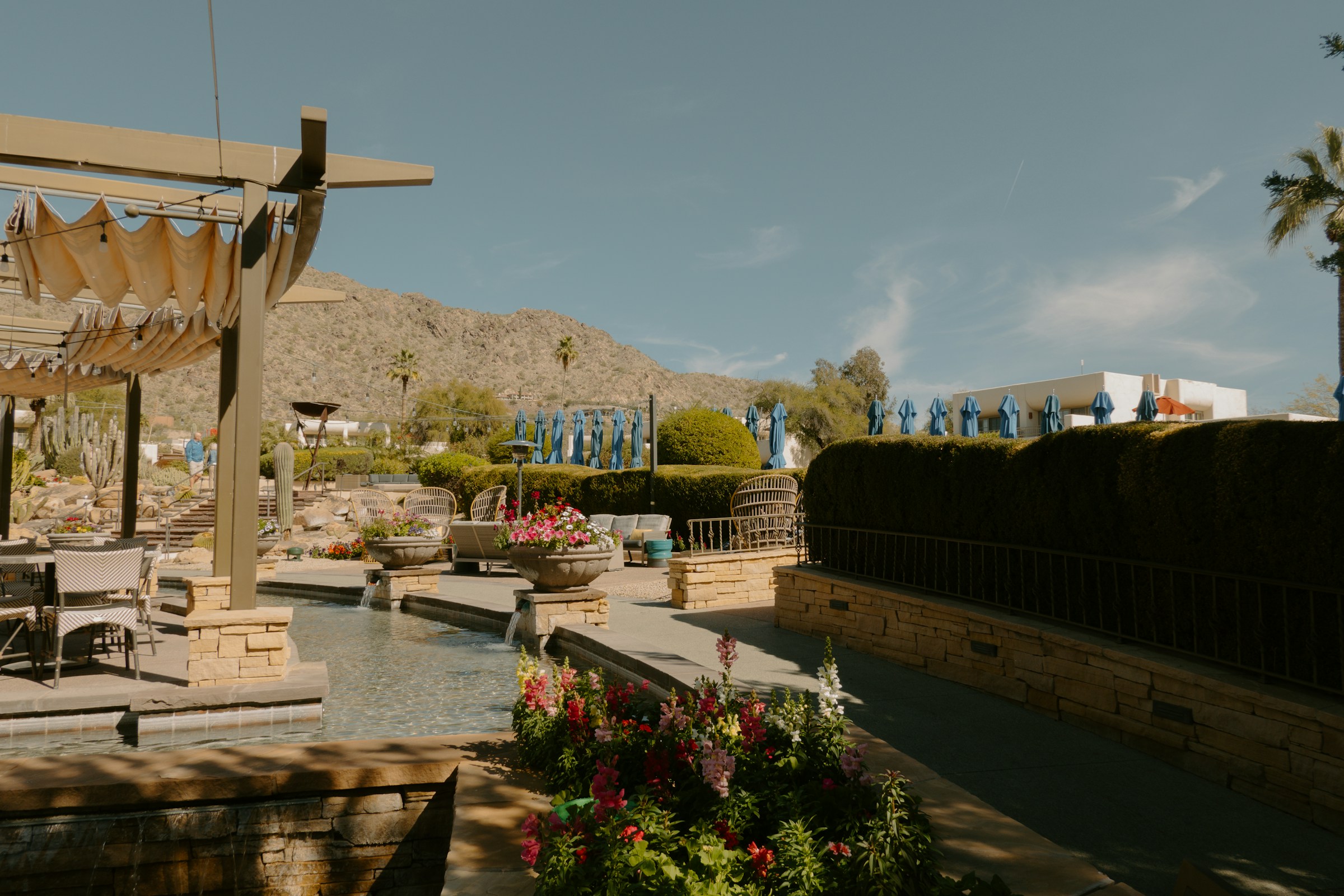 A sunlit desert resort patio with mountains in the distance