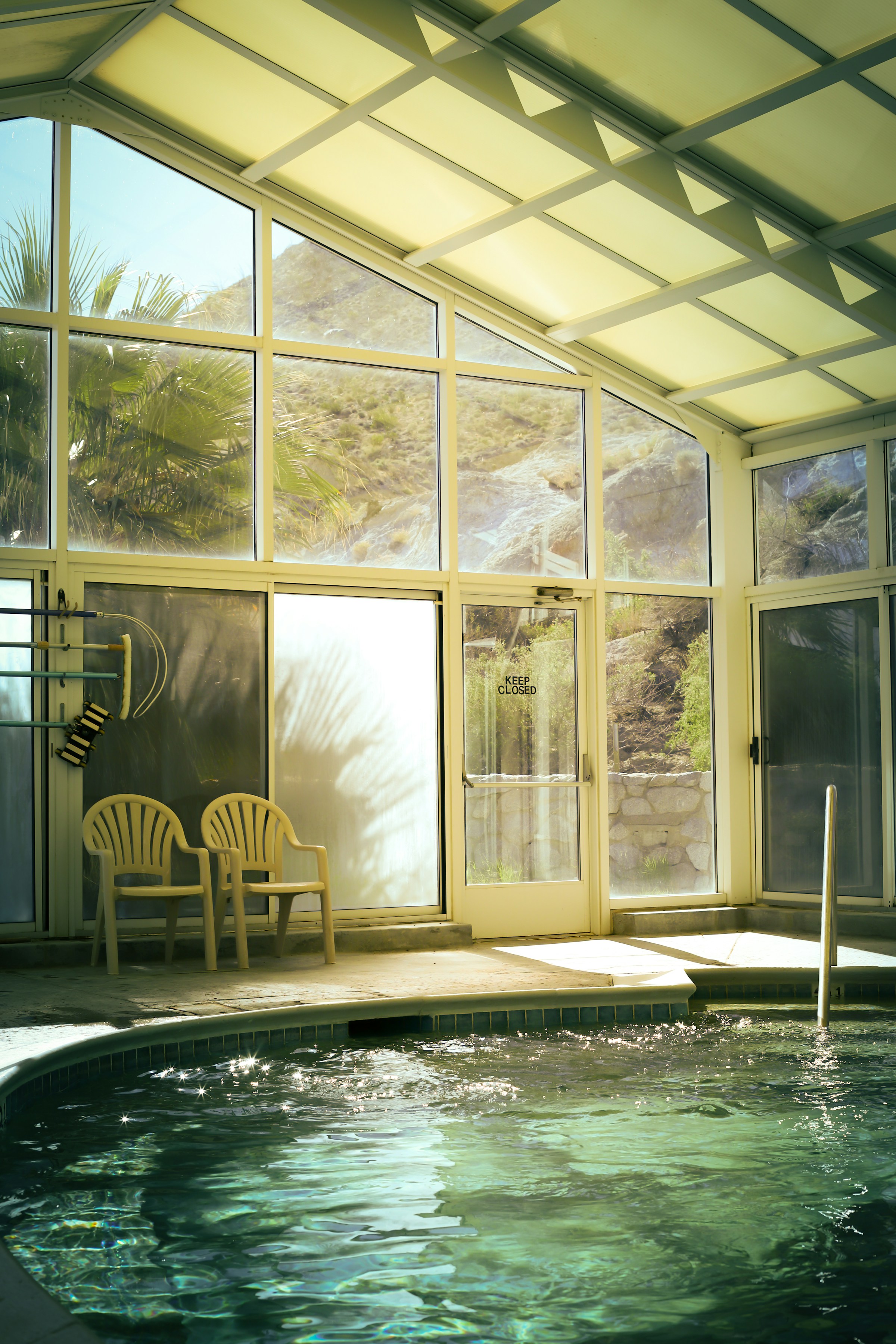 An indoor spa pool with a mountain view through glass walls